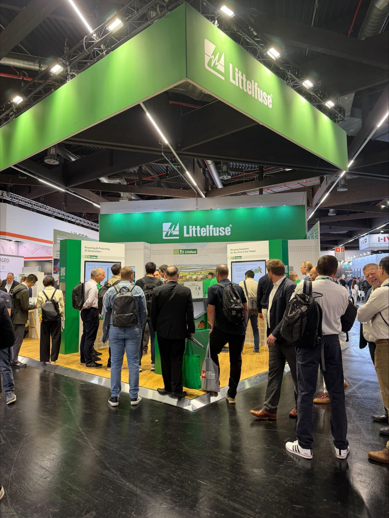 Littelfuse tradeshow booth with attendees and green branded signage